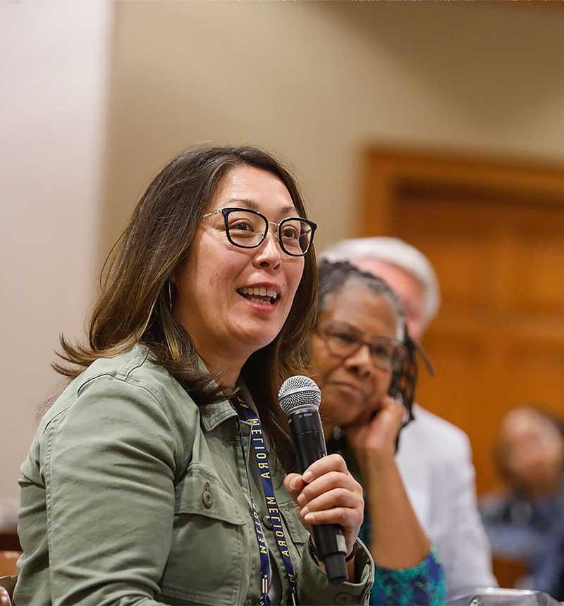 woman in glasses with microphone during a conference