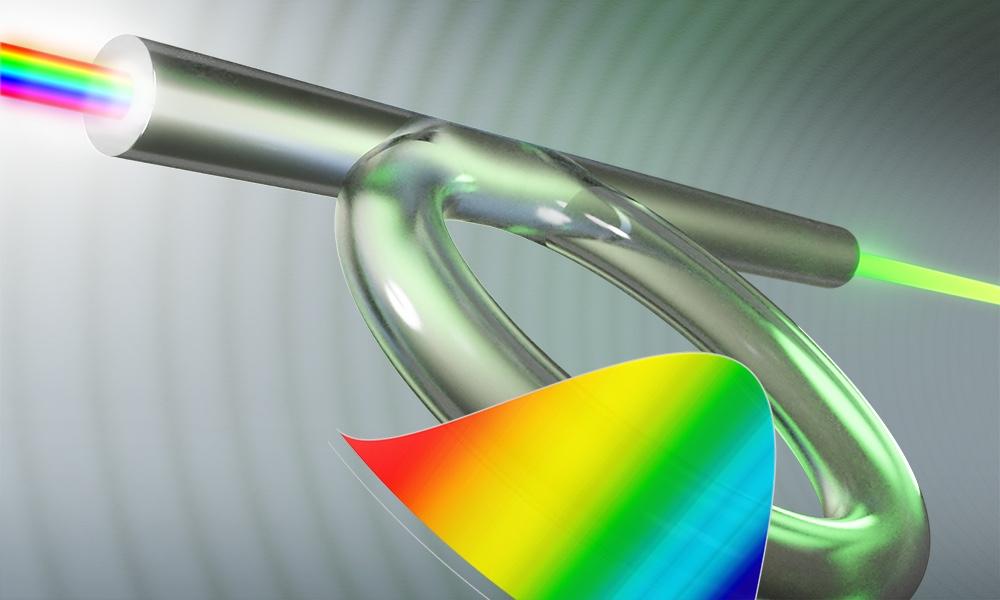 illustration of the optical fiber Kerr resonator with rainbow pattern in foreground.